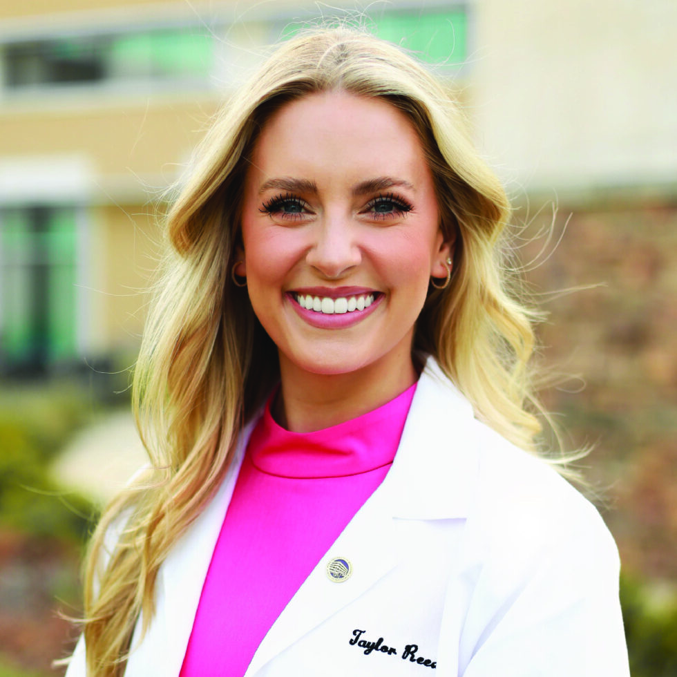 Dr. Taylor Reed in a white coat, smiling outdoors